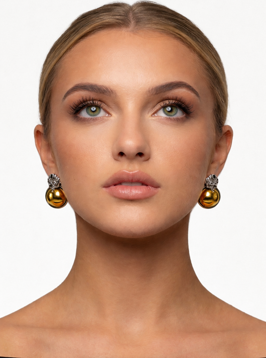Woman wearing gold earrings with a neutral background